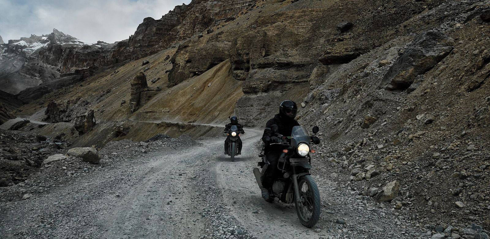 Two riders on Royal Enfield Himalayans on a rocky mountain road